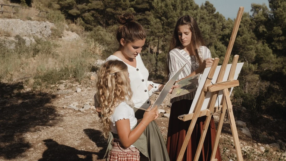 Tres mujeres pintan juntas al aire libre